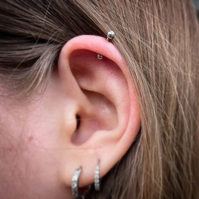 Helixpiercing am oberen Ohr mit silberfarbenem Schmuck
